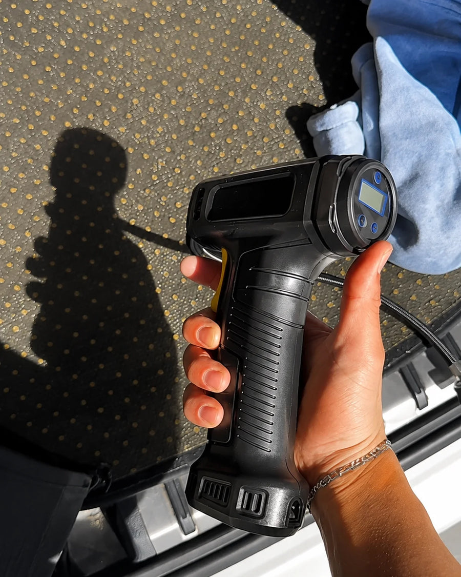 UGC photo - Driver holding cordless inflator near an open vehicle